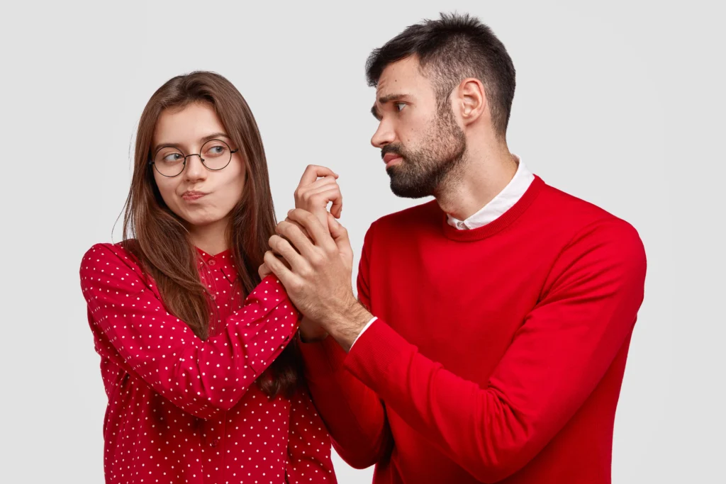 Un homme regarde sa compagne avec inquiétude après une dispute, illustrant les signes qu’un homme ne veut pas vous perdre.